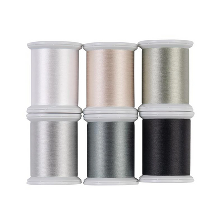 Set of six spools of thread in various colors on a white background