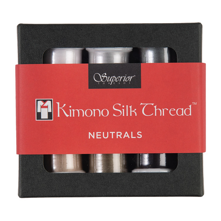 A boxed set of kimono silk thread in the 'Neutrals' colorway, featuring six spools of silver and black thread visible through a black window box with a red paper label.