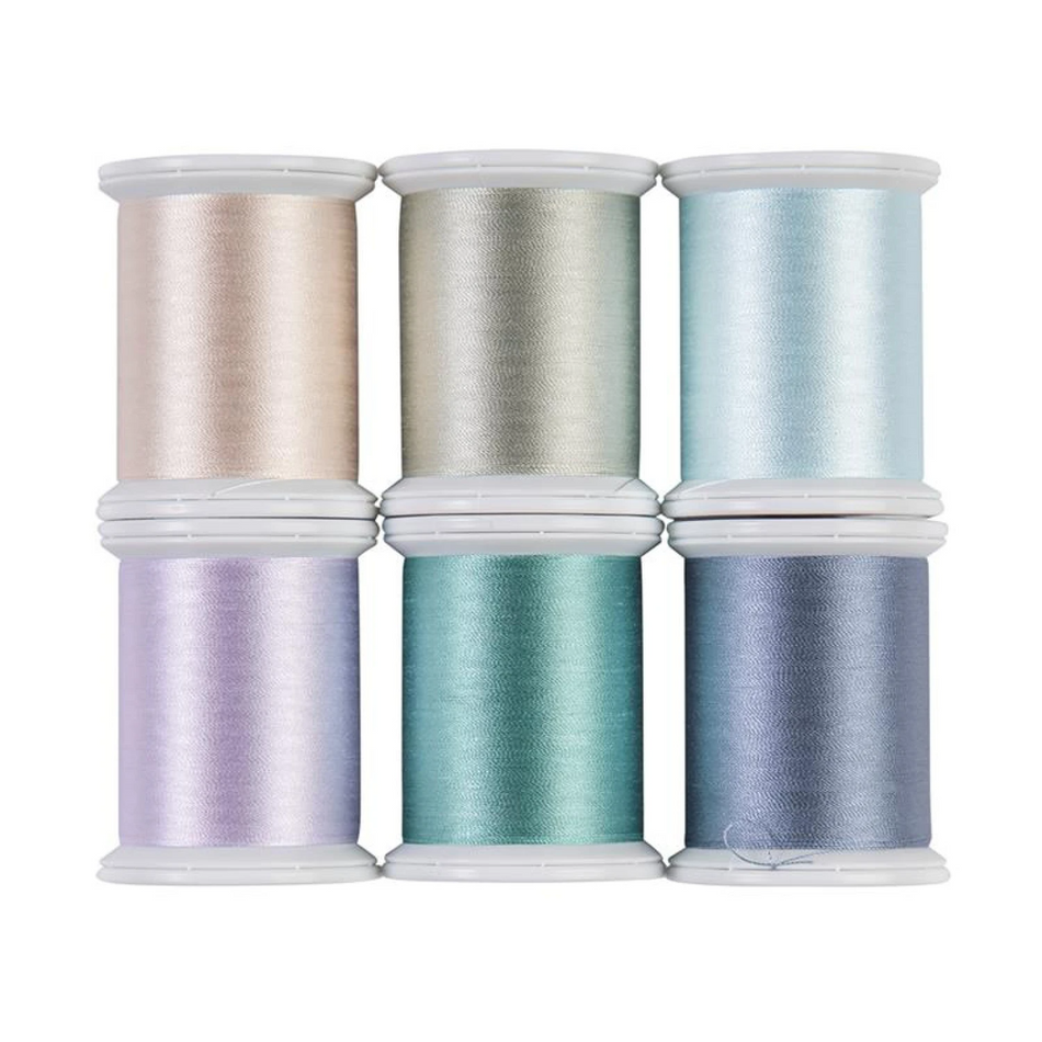 Six spools of shimmering satin thread arranged in a 2x3 grid on a white background. The colors include champagne, silver, icy blue, lavender, teal, and periwinkle.
