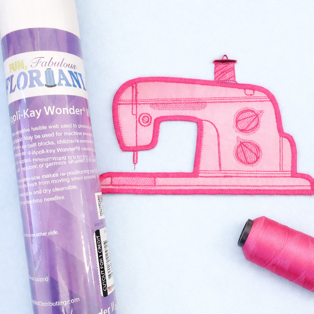 Floriani fabric swatch with pink sewing machine design and thread on a white background