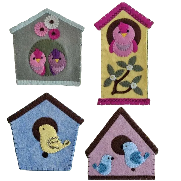 Four colorful birdhouse ornaments on a green leafy background