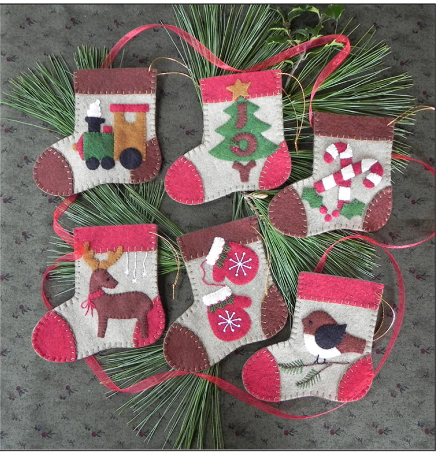 Cover of a pattern book titled 'Warm Feet' featuring Christmas stockings on a gray background.