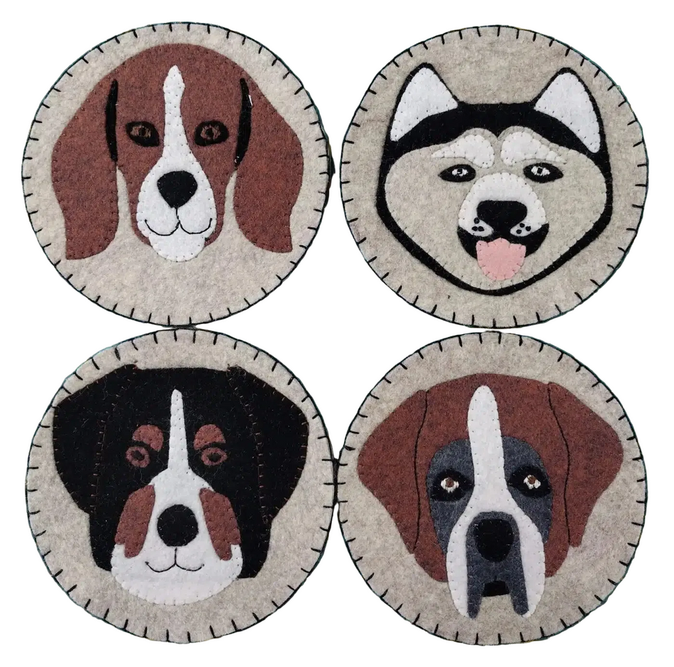 Four circular dog face patches on a green cutting mat with grid lines.